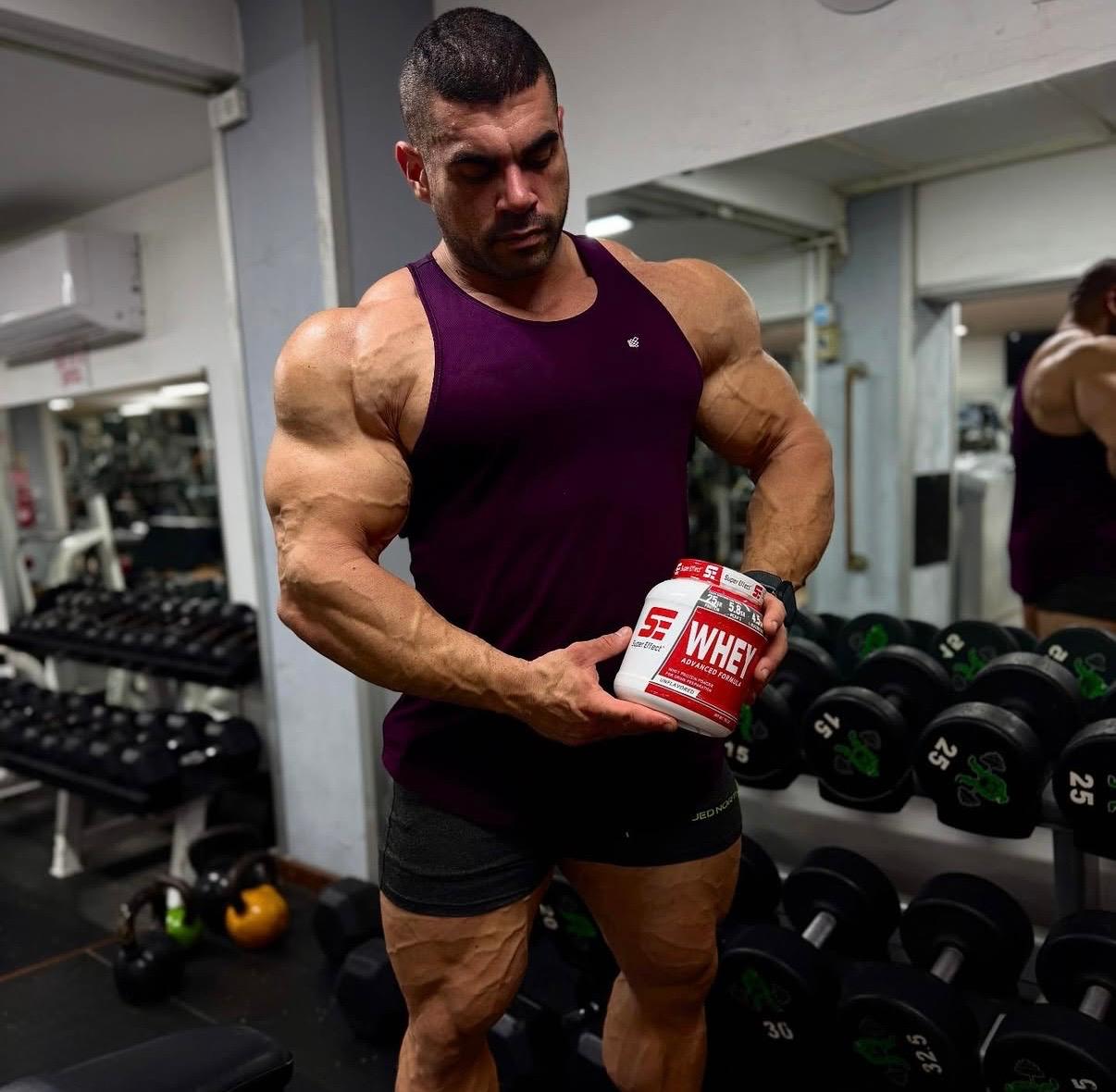 מתאמן בחדר כושר מחזיק אבקת חלבון WHEY סופר אפקט